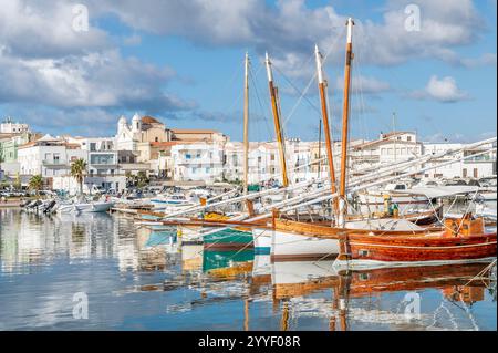Farbenfrohe Holzboote spiegeln sich im Wasser des Hafens von Calasetta, Sant'Antioco, Italien Stockfoto