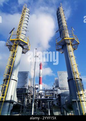 Eine große Fabrik mit dickem Rauch, der aus ihren hohen Schornsteinen in die Atmosphäre strömt Stockfoto