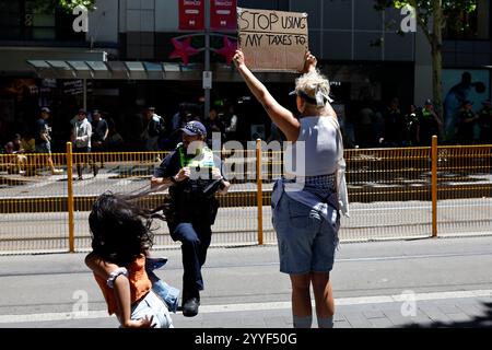 Melbourne, Australien. Dezember 2024. Ein Demonstrant hält während der Kundgebung ein Plakat. Demonstranten hielten eine Kundgebung in Melbourne CBD ab und forderten Sanktionen gegen Israel an Weihnachten, um die zionistische Aggression zu beenden und Menschenleben im Nahen Osten zu ehren. (Foto: YE Myo Khant/SOPA Images/SIPA USA) Credit: SIPA USA/Alamy Live News Stockfoto