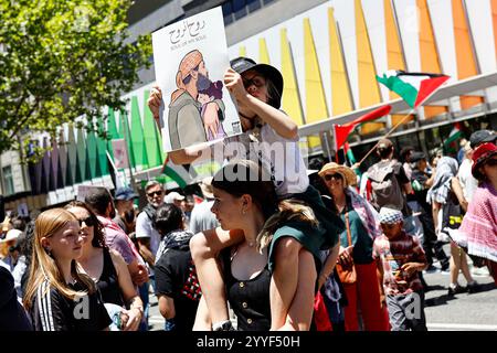 Melbourne, Australien. Dezember 2024. Ein Demonstrant hält während der Kundgebung ein Plakat. Demonstranten hielten eine Kundgebung in Melbourne CBD ab und forderten Sanktionen gegen Israel an Weihnachten, um die zionistische Aggression zu beenden und Menschenleben im Nahen Osten zu ehren. (Foto: YE Myo Khant/SOPA Images/SIPA USA) Credit: SIPA USA/Alamy Live News Stockfoto