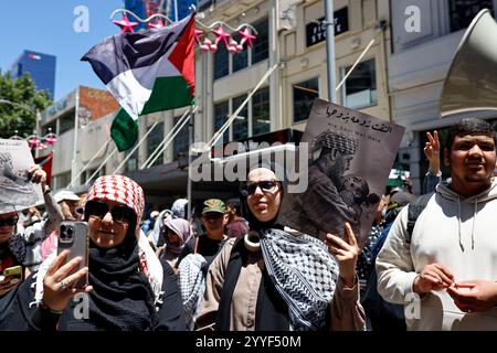 Melbourne, Australien. Dezember 2024. Ein Demonstrant hält während der Kundgebung ein Plakat. Demonstranten hielten eine Kundgebung in Melbourne CBD ab und forderten Sanktionen gegen Israel an Weihnachten, um die zionistische Aggression zu beenden und Menschenleben im Nahen Osten zu ehren. (Foto: YE Myo Khant/SOPA Images/SIPA USA) Credit: SIPA USA/Alamy Live News Stockfoto