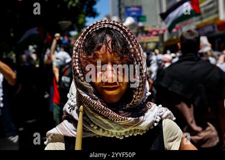 Melbourne, Australien. Dezember 2024. Ein Demonstrant spielt während der Kundgebung eine Trommel. Demonstranten hielten eine Kundgebung in Melbourne CBD ab und forderten Sanktionen gegen Israel an Weihnachten, um die zionistische Aggression zu beenden und Menschenleben im Nahen Osten zu ehren. (Foto: YE Myo Khant/SOPA Images/SIPA USA) Credit: SIPA USA/Alamy Live News Stockfoto