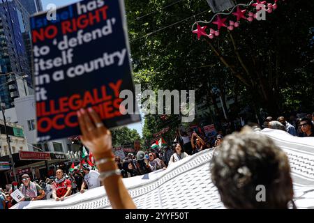 Melbourne, Australien. Dezember 2024. Ein Demonstrant hält während der Kundgebung ein Plakat. Demonstranten hielten eine Kundgebung in Melbourne CBD ab und forderten Sanktionen gegen Israel an Weihnachten, um die zionistische Aggression zu beenden und Menschenleben im Nahen Osten zu ehren. (Foto: YE Myo Khant/SOPA Images/SIPA USA) Credit: SIPA USA/Alamy Live News Stockfoto