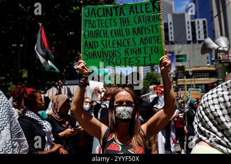 Melbourne, Australien. Dezember 2024. Ein Demonstrant hält während der Kundgebung ein Plakat. Demonstranten hielten eine Kundgebung in Melbourne CBD ab und forderten Sanktionen gegen Israel an Weihnachten, um die zionistische Aggression zu beenden und Menschenleben im Nahen Osten zu ehren. (Foto: YE Myo Khant/SOPA Images/SIPA USA) Credit: SIPA USA/Alamy Live News Stockfoto