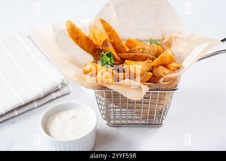 Blick auf einen Korb mit gewürzten Kartoffelkeilen. Stockfoto