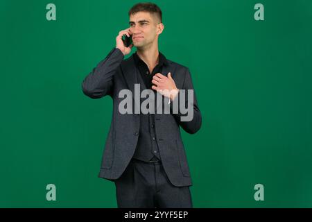 Ein Indianer sieht angespannt und frustriert aus, während er mit seinem Mobiltelefon in einer modernen Büroumgebung spricht und Anzeichen von Wut und Stress zeigt. Hochwertige Fotos Stockfoto