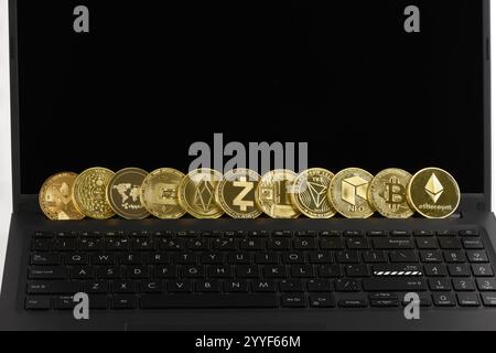 Goldene Kryptowährung auf Tastatur Laptop, Bitcoin, Ethereum, Litecoin, Dashcoin, XRP, EOS, NEO, TRX, MONERO, Zcach, IOTA und Ripple Coins. Krypto ist Stockfoto