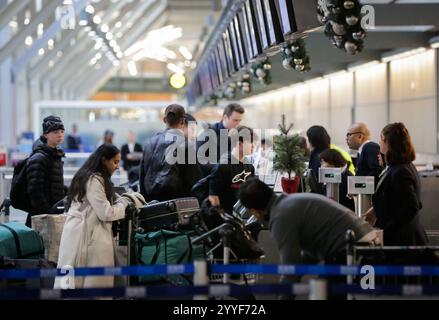 Vancouver, Kanada. Dezember 2024. Reisende stehen am Abfertigungsschalter einer Fluggesellschaft am Vancouver International Airport in Richmond, British Columbia, Kanada, am 21. Dezember 2024 an. Weihnachten ist gleich um die Ecke, und der internationale Flughafen Vancouver bereitet sich auf seine geschäftigste Reisesaison vor. Quelle: Liang Sen/Xinhua/Alamy Live News Stockfoto