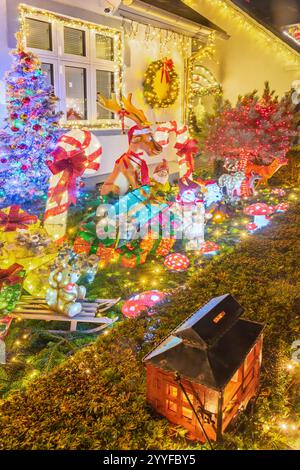 Eine Straße mit bunt dekorierten Häusern mit Weihnachtsbeleuchtung in Hinnerup, Jütland, Dänemark. Stockfoto