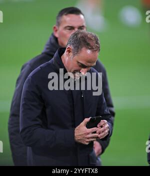 München, Deutschland, 20. Dezember 2024: Fussball, Herren, Bundesliga, Saison 2024/2025, FC Bayern München - RB Leipzig, Allianz Arena Oliver Mintzlaff, Aufsichtsratsvorsitzender (RB Leipzig) mit Blick auf sein Handy, Smartphone DFB, DFL-Vorschriften verbieten jede Verwendung von Fotografien als Bildsequenzen und/oder Quasi-Video Stockfoto