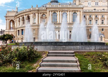 Ein Brunnen vor einem Gebäude mit vielen Stufen. Der Brunnen sprüht Wasser in die Luft Stockfoto