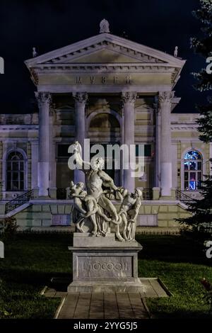 Eine Statue eines Mannes mit einem Schwert und einer Frau mit einem Hund. Die Statue befindet sich vor einem Gebäude mit Säulen Stockfoto