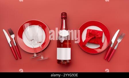 Das Konzept, den Valentinstag mit einem Galadinner in einem schicken Restaurant, Weingläsern, Champagner und einer roten Geschenkbox zu feiern Stockfoto