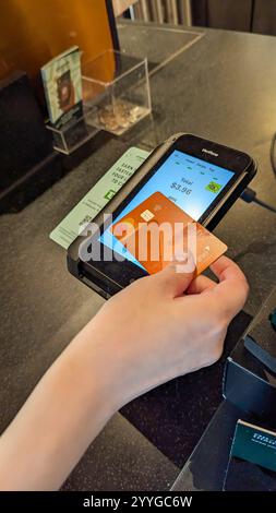 Eine Frau, die beim Starbucks Kaffee bezahlt Stockfoto