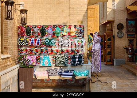 Ethnische bunte traditionelle Mütze und Taschen mit traditionellem usbekischen Ornament auf dem Straßenmarkt in Chiwa, Usbekistan, Zentralasien. Stockfoto