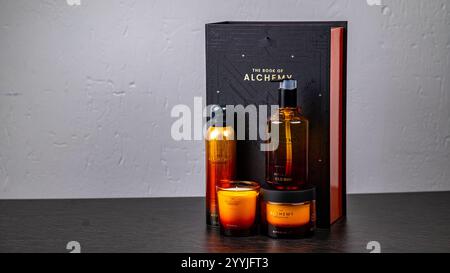 Jurmala, Lettland 14.12.2024: Körperpflegekosmetik- Rituale das Buch der Alchemie. Elegante Ausstellung von Alchemie-Buch und Luxuskerzen auf dunkler Oberfläche in Stockfoto