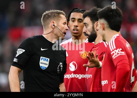 Manchester, Großbritannien. Dezember 2024. Spieler von Manchester United sprechen mit Schiedsrichter Craig Pawson, nachdem er Bournemouth während des Premier League-Spiels Manchester United gegen Bournemouth am 22. Dezember 2024 in Old Trafford, Manchester, Großbritannien, einen Elfmeter zugesprochen hat (Foto: Craig Thomas/News Images) in Manchester, Großbritannien am 22. Dezember 2024. (Foto: Craig Thomas/News Images/SIPA USA) Credit: SIPA USA/Alamy Live News Stockfoto