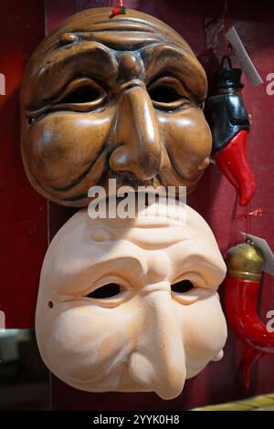 Neapel, Italien - 12. Dezember 2024: Handgefertigte Masken von Pulcinella auf dem Stand in San Gregorio Armeno, der berühmten Straße der Weihnachtsgeschenke. Stockfoto