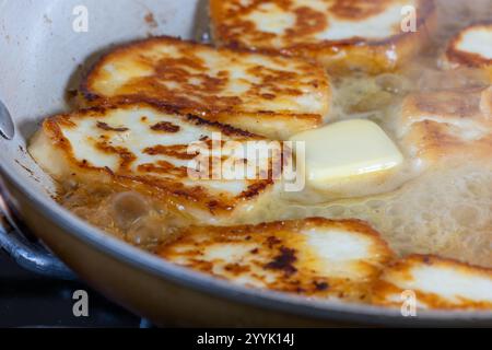 Eine Pfanne mit gebratenem halloumi-Käse wird mit einer goldbraunen Kruste gezeigt. Kochen in heißer Butter. Das Gericht sieht köstlich und einladend aus Stockfoto