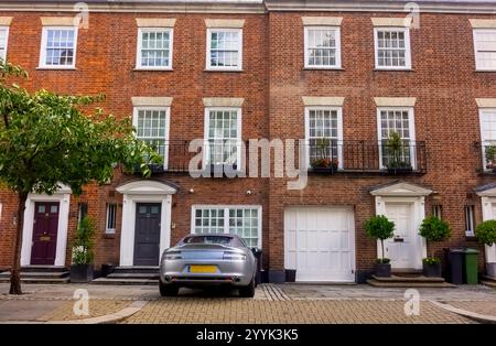 London, Großbritannien - 15. Juli 2023: Vor dem teuren Stadthaus aus edwardianischem Backstein am Park Walk in Chelsea, London mit dem Auto von Aston Martin in der Einfahrt Stockfoto