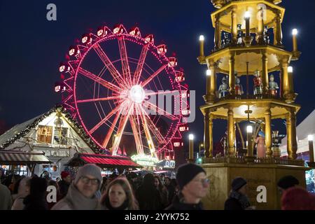 Riesenrad hinter einer Weihnachtspyramide auf dem Weihnachtsmarkt am Alexanderplatz, Berlin, 21.12.2024 Stockfoto