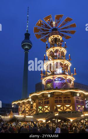 Eine Weihnachtspyramide vor dem Berliner Fernsehturm auf dem Weihnachtsmarkt am Alexanderplatz, Berlin, 21. Dezember 2024 Stockfoto