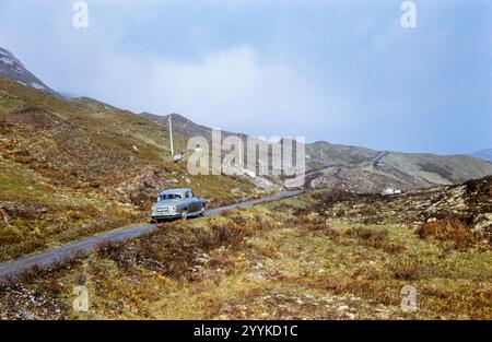 Historisches Foto eines alten Rover Autos, der in den 1960er Jahren auf einer abgelegenen einspurigen Straße in Applecross, Schottland, Großbritannien geparkt wurde Stockfoto