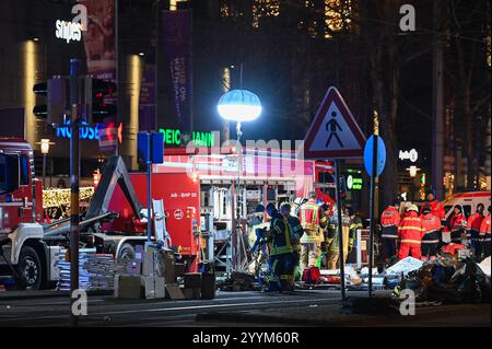 Magdeburg, Deutschland. Dezember 2024. Rettungsdienste auf der Ernst-Reuter-Allee vor dem Allee-Center. Ein Auto ist auf einen Weihnachtsmarkt in Magdeburg gestürzt. Es gibt mehrere Todesopfer und viele Verletzte. Quelle: Heiko Rebsch/dpa/Alamy Live News Stockfoto