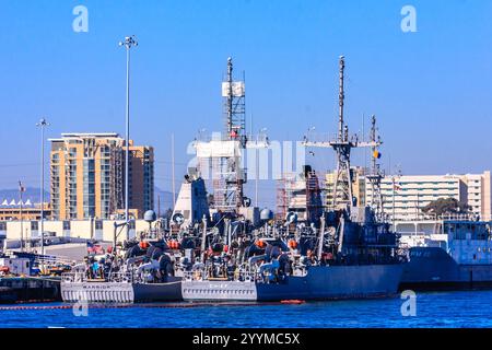 Zwei große Marineschiffe legen an einem Pier an. Die Schiffe sind von einem großen Gewässer umgeben Stockfoto