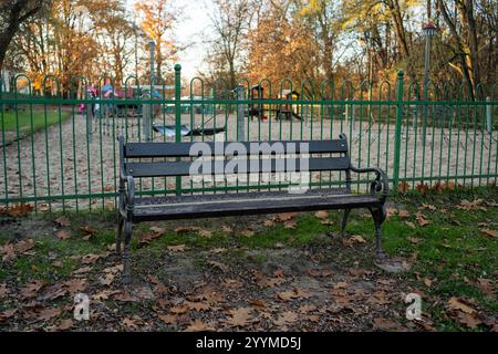 Eine leere Bank am Spielplatz im Park Stockfoto