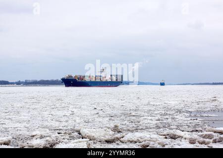 Containerschiff bricht durch Thick Ice auf der gefrorenen Elbe in Hamburg Stockfoto