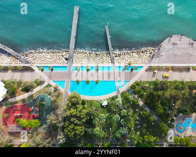 Ein atemberaubender Blick aus der Vogelperspektive auf die Limassol Molos Promenade in Zypern, mit dem pulsierenden Park am Meer und den von Palmen gesäumten Wegen im Mittelmeer Stockfoto