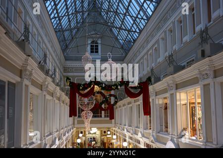 Im Zentrum der Stadt zieren festliche Dekorationen eine elegante Einkaufspassage mit atemberaubender Architektur Stockfoto