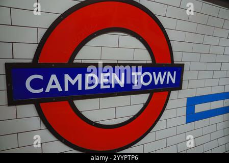 Das berühmte rot-blaue Schild der U-Bahn von Camden Town ist an weiß gekachelten Wänden angebracht und zeigt die öffentlichen Verkehrsmittel Londons während der Weihnachtszeit Stockfoto