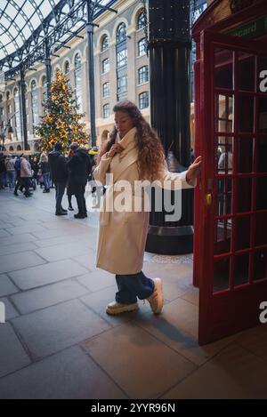 Festliche Szene in London mit roter Telefonzelle und Weihnachtsbaum Stockfoto