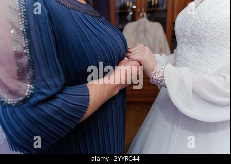 Intimer Moment der Verbindung zwischen Mutter und Braut in eleganter Kleidung. Stockfoto