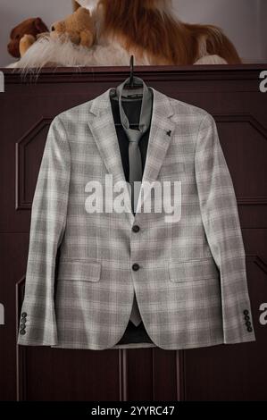 Eleganter Anzug mit grauem Karomuster und Krawatte auf hölzernem Hintergrund. Stockfoto