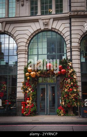 Feierlicher Eingang zum Gebäude mit rotem Postfach in London zu Weihnachten Stockfoto