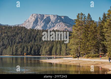 30. Oktober 2024, Crno Jezero, Montenegro: Touristen wandern am Ufer des Schwarzen Sees und genießen den atemberaubenden Blick auf das Durmitor-Massiv in na Stockfoto