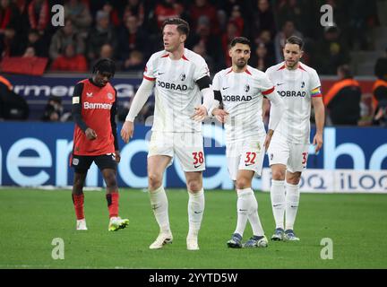 Leverkusen, Deutschland. Dezember 2024. Von links Jeremie Frimpong (Bayer), Michael Gregoritsch (Freiburg), Vincenzo Grifo (Freiburg), Christian Guenter (Freiburg), Leverkusen, Deutschland, 21.12.2024, Fußball-Bundesliga, Spieltag 15, Bayer 04 Leverkusen - SC Freiburg. DFL-VORSCHRIFTEN VERBIETEN DIE VERWENDUNG VON FOTOS ALS BILDSEQUENZEN UND/ODER QUASI-VIDEO. Credit: Jürgen Schwarz/Alamy Live News Stockfoto