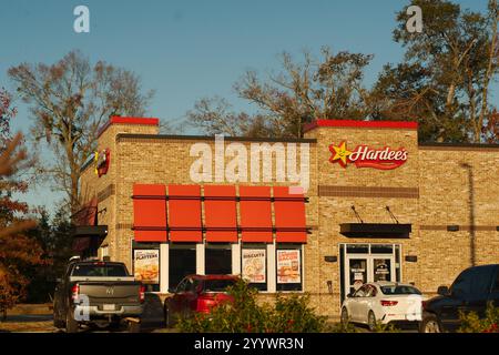 Redaktionelle Verwendung nur Wide View 19. Dezember 2024. Harlem, GA, USA. Außenschild von Hardee's Restaurant. Sonnenschein am frühen Morgen mit blauem Himmel. Stockfoto