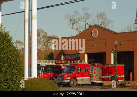 Redaktionelle Verwendung nur Wide View 19. Dezember 2024. Harlem, GA, USA. Feuerwehrhaus außen mit roten Feuerwehrfahrzeugen draußen. Sonnenschein am frühen Morgen mit blauem Himmel. Stockfoto