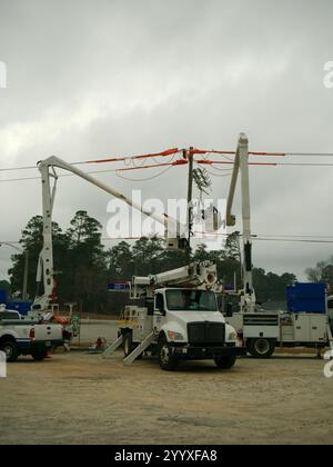 Nur redaktionelle Verwendung Weitsicht 18. Dezember 2024 Columbia County, GA USA. Mehrere weiße Elektrofahrzeuge arbeiten an Drähten. Hydraulikschaufel mit Stockfoto