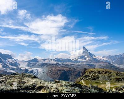 Panoramablick auf den Gipfel des Matterhorns mit komplexen Bergen in den Schweizer Alpen. Fantastischer Blick auf Matterhorn auf blauem Himmel und Wolkenhintergrund. Touristenziel Stockfoto