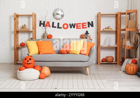 Das Innere des stilvollen Wohnzimmers mit Sofa, Kürbissen und Discokugel ist für Halloween-Party dekoriert Stockfoto
