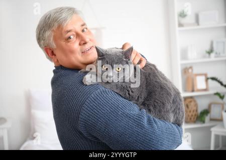 Seniorenmann mit süßer Katze zu Hause Stockfoto
