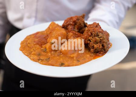 Traditionell verwöhnt ein Kellner ein Festmahl mit Yamsbrei - Asaro und Fisch bei einer besonderen Veranstaltung Stockfoto