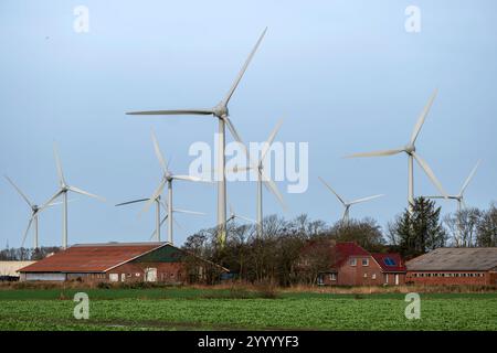 Norden, Niedersachsen, Deutschland - Windkraftanlagen, Windpark in der Nähe von Norden in Ostfriesland. Vor einem Bauernhof mit Wohnhaus. Stockfoto