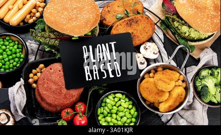 Pflanzliches Lebensmittelkonzept: Vegane Burger, Würstchen, vegetarische Nuggets, frisches Gemüse und Saucen Stockfoto