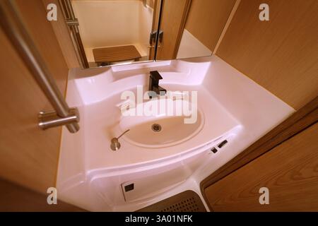 Badezimmer auf einem Reiseboot mit einem Fenster über dem Zimmer mit Tageslicht Stockfoto
